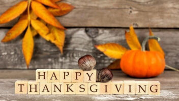 autum leaves with wooden blocks that say 'happy thanksgiving'