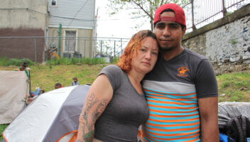 Salvatore Gonzalez and his fiancée stand near the Kensington Avenue railroad overpass in Philadelphia, Pa. (Emma Lee/WHYY)