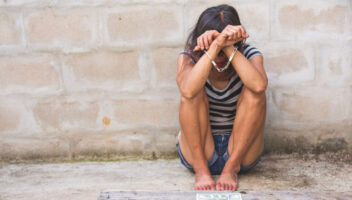 woman in handcuffs sitting on the ground