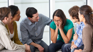 people consoling another person in group therapy